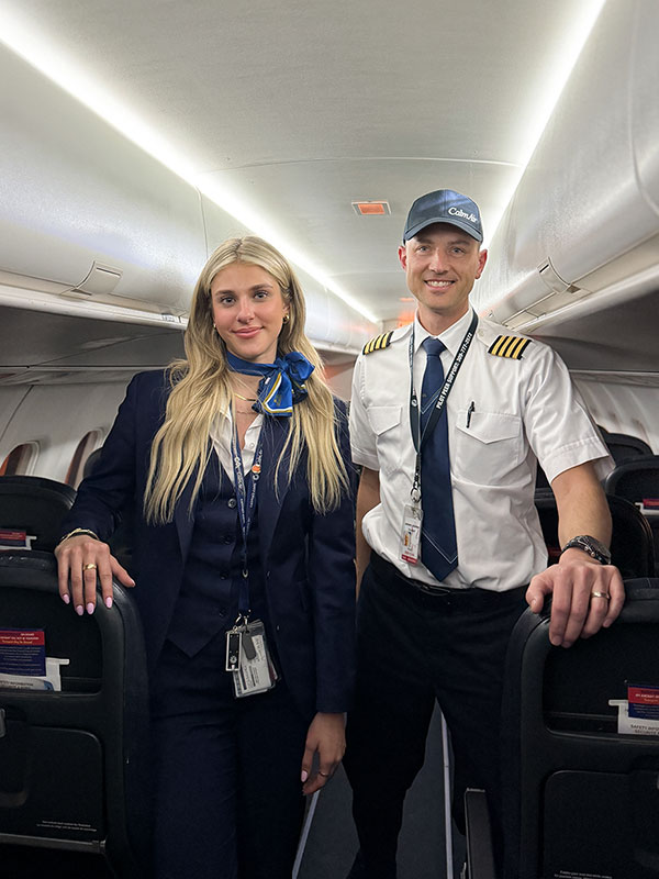 L'h&ocirc;tesse de l'air et le pilote sourient dans le compartiment passagers.